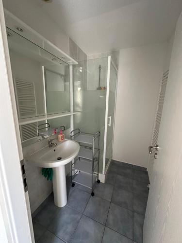 une salle de bain avec un lavabo et une douche dans l'établissement Appart City, à Saint-Louis