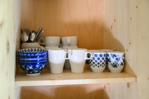 a shelf with blue and white cups and utensils at Hájenka Obrázek in Volary
