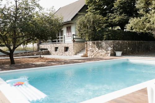 a swimming pool with a house in the background at Almond Buna PoolHouse in Mostar