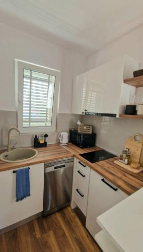 a kitchen with white cabinets and a sink at Vila Damir in Gradac