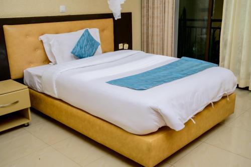 a bedroom with a large bed with blue sheets at QUALITY INN HOTEL Kigali in Kigali