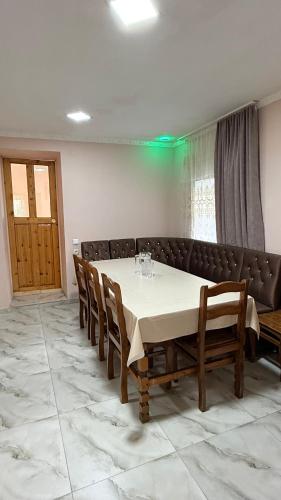 a dining room with a table and chairs and a couch at Nizharadze's Tower in Ushguli