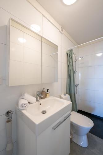 a white bathroom with a sink and a toilet at Steam Apartments - Eidhøgda 6 in Tromsø