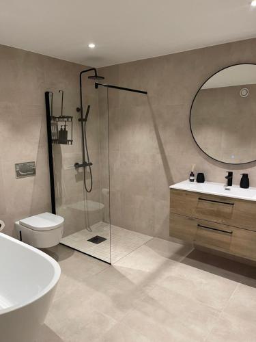 a bathroom with a shower and a toilet and a sink at 2 leiligheter med panoramautsikt in Bergen