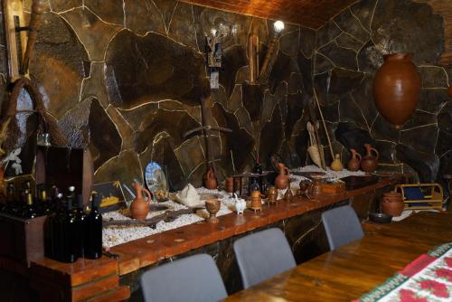 a dining room with a table and a stone wall at Hotel Hobbiton near Vardzia Caves in T'mogvi