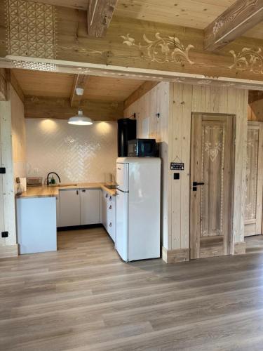 a kitchen with a white refrigerator in a room at Stylowa Chata in Zakopane
