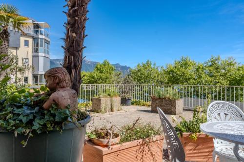 a garden with a statue and a table and chairs at Lakeside-Apartment-2 Appartement avec une grande terrasse et vue panoramique sur le lac in Vevey