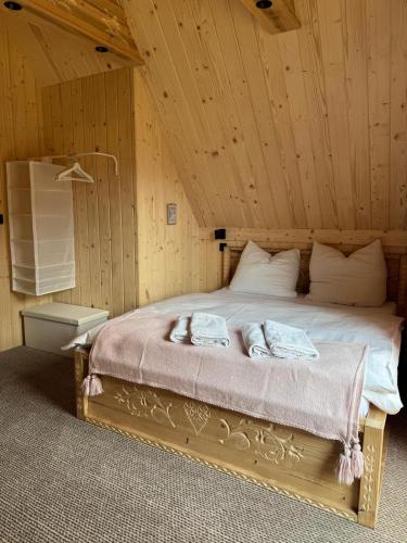 a bedroom with a bed with two towels on it at Stylowa Chata in Zakopane
