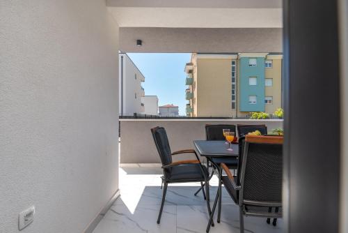 a room with a table and chairs on a balcony at Apartment Cvit in Trogir