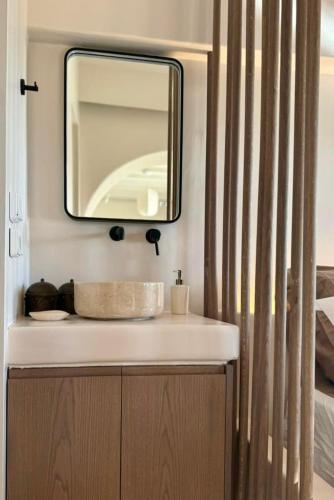 a bathroom with a sink and a mirror at Conte Mykonos II in Aggelika
