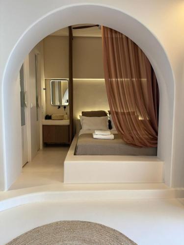 a room with a bed with a mirror and a tub at Conte Mykonos II in Aggelika