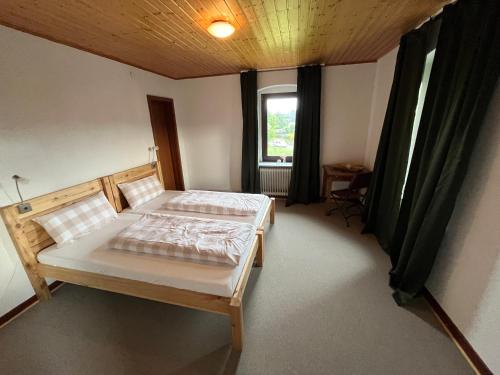 a bedroom with two beds and a window at Gasthaus zur Heide am Nürburgring in Welcherath