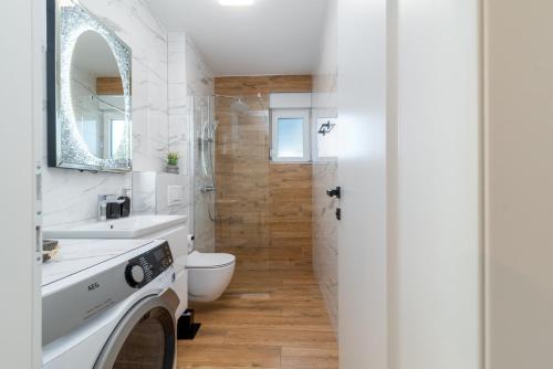 a bathroom with a toilet and a sink and a shower at Apartment Cvit in Trogir