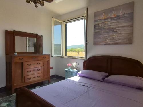 カステルサルドにあるVilletta Olivia Casa in collina vista mareのベッドとドレッサーと窓のある寝室