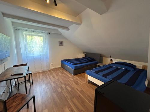 a room with two beds and a table and a desk at Wienerwald Juwel in Irenental