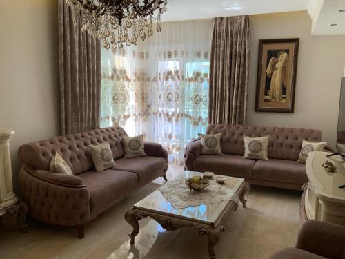 a living room with two couches and a table at Alexandra Luxury Apartment in Alexandroupoli
