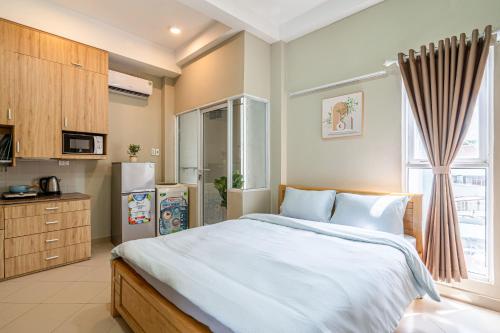 a bedroom with a large bed and a kitchen at Urban Stay Apartment in Ho Chi Minh City