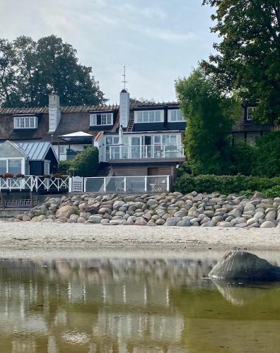a house on the shore of a body of water at Strandhytten in Ålsgårde