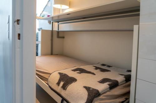 a small bedroom with a bed with a blanket on it at Strandhytten in Ålsgårde