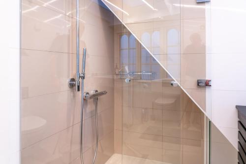a shower with a glass door in a bathroom at Strandhytten in Ålsgårde