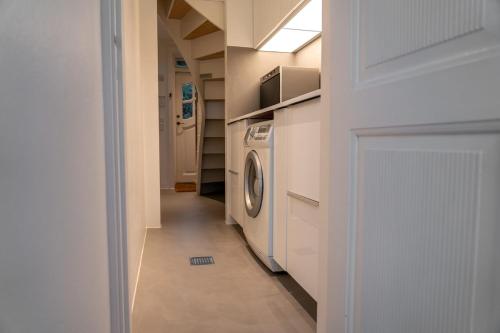 a hallway with a washer and dryer in a house at Strandhytten in Ålsgårde