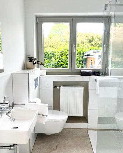 a white bathroom with a toilet and a window at Exklusive Wohnung mit Ahrblick 3 in Bad Neuenahr-Ahrweiler