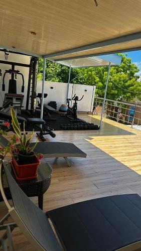 a gym with a deck with chairs and a table at Grande Maldives Inn in Himmafushi