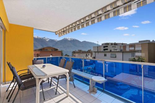 a balcony with a table and chairs and a view at Casa Verbanella - Objekt 7500 in Minusio