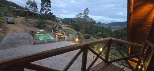 a view of a pool from a balcony of a house at Chalé Familiar com Jacuzzi e Piscina in Tubarão