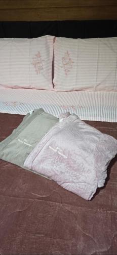 a bed with a white blanket on top of it at Chalé Familiar com Jacuzzi e Piscina in Tubarão