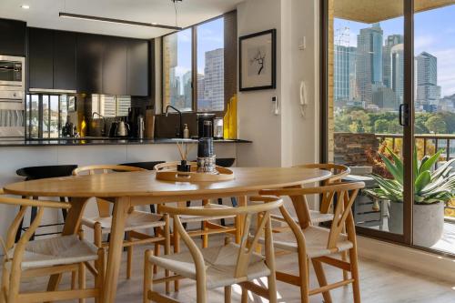 a kitchen and dining room with a wooden table and chairs at Inner City Harbour Views With Parking in Sydney