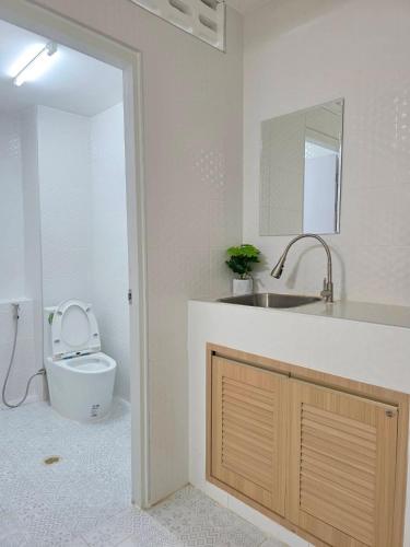 a bathroom with a toilet and a sink and a mirror at Nan Square II in Bangkok