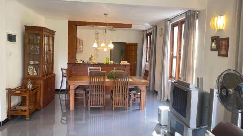 a kitchen and dining room with a table and a television at Sweet Villa Hotel in Peradeniya