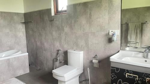 a bathroom with a white toilet and a sink at Sweet Villa Hotel in Peradeniya