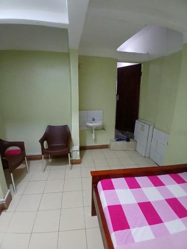 a room with a bed and a sink in it at muffler motel bukesa in Kampala