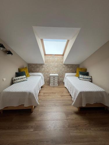 a attic room with three beds and a skylight at Había Una Vez in El Espinar