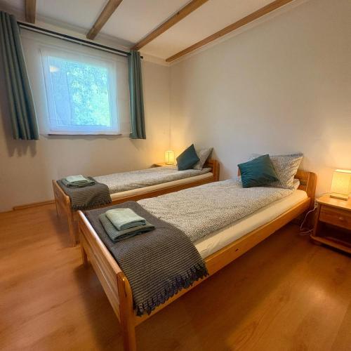 two twin beds in a room with a window at Domek nad Paklicą in Nowy Dworek