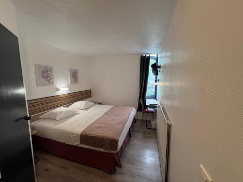 a bedroom with a bed in a small room at Hôtel Amarante in Besançon