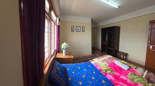 a bedroom with a bed and a window at Holiday hills homestay in Bomdila