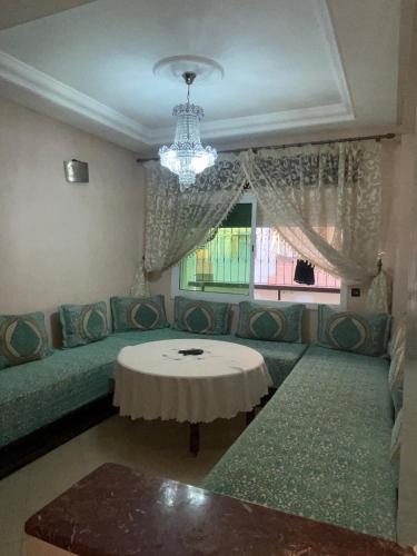 a living room with a couch and a table at Appartement familiale au Complexe Résidentiel Safae Tangier in Gzennaïa