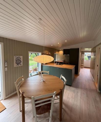 a dining room and kitchen with a wooden table and chairs at Cozy 6 person holiday home in Juelsminde - 5 minutes walk to the beach in Sønderby