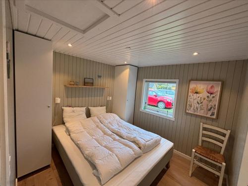 a bed in a bedroom with a window and a chair at Cozy 6 person holiday home in Juelsminde - 5 minutes walk to the beach in Sønderby
