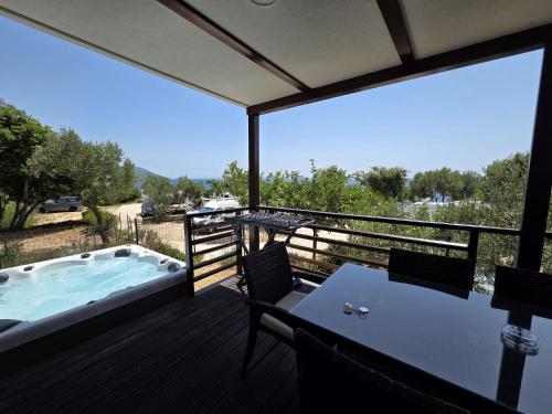 a deck with a hot tub and a table and chairs at Lavanda Mobile Homes & Villas in Orebić