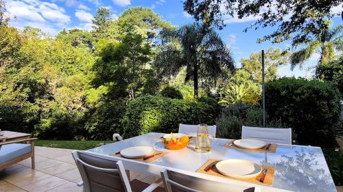 a table and chairs on a patio with trees at Casa Paraíso, Britopolis, Beachfront in Fomento