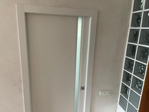 a white door in a room with windows at Appartamenti Lago di Como in Valbrona