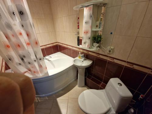 a bathroom with a tub and a toilet and a sink at Cozy apartment in Ventspils