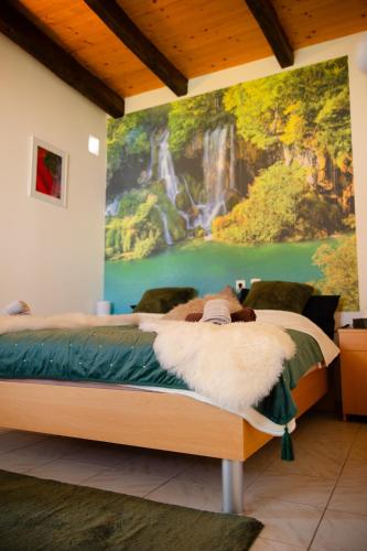 a bedroom with a bed with a painting on the wall at Kuća za odmor Mia in Stankovac