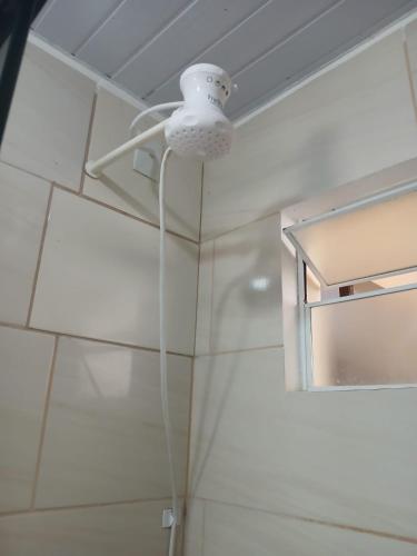 a shower with a white light on the ceiling at Casa das Embaúbas 05 in São José