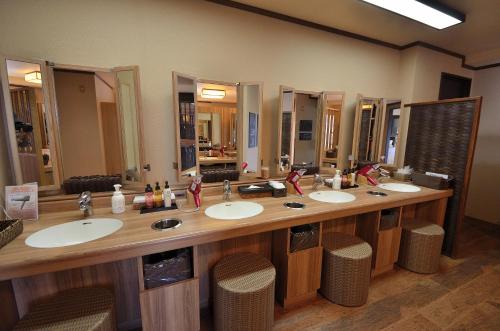 a large bathroom with four sinks and mirrors at Dormy Inn Hirosaki in Hirosaki