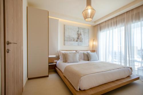 ein Schlafzimmer mit einem großen Bett und einem großen Fenster in der Unterkunft Anna Luxury Villas by RentalsPro - Nea Flogita Halkidiki in Flogita